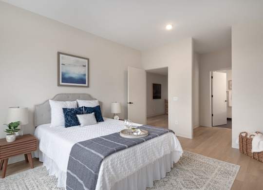 A bedroom with a large bed and a painting on the wall.