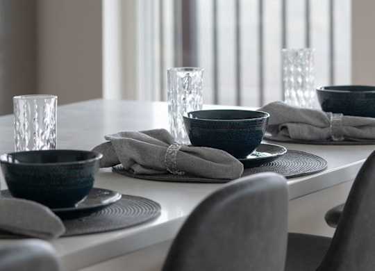 A table set for two with a white tablecloth and two chairs.