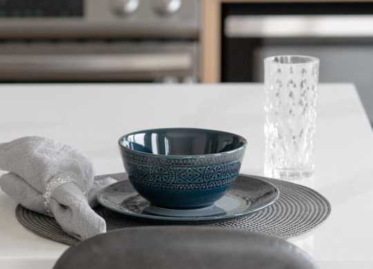 A bowl on a plate on a chair.