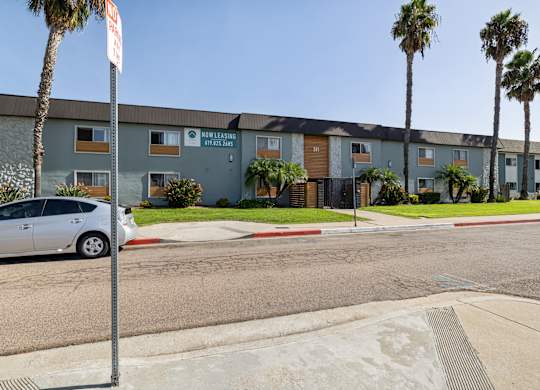 A street view of a building with a car parked in front.