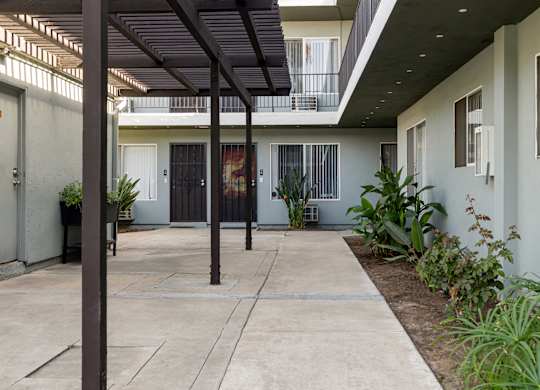 A patio with a black awning and a concrete floor.