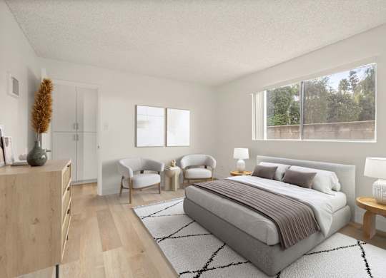 A bedroom with a large bed, a chair, and a nightstand.