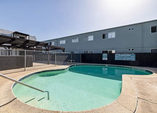 A small pool with a metal fence around it.