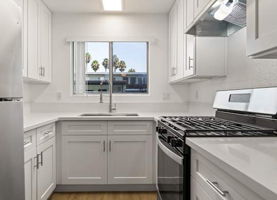 A kitchen with white cabinets and appliances.