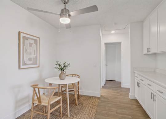 A dining room with a table and chairs.