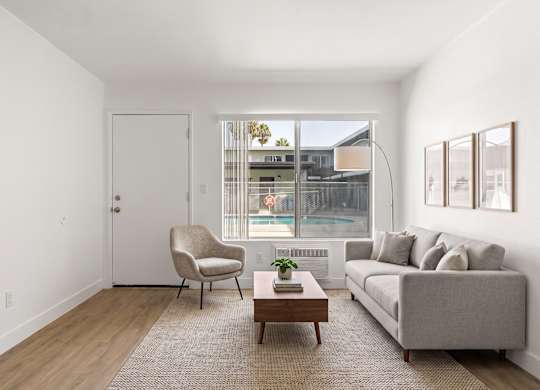A living room with a grey couch, a chair, and a coffee table.