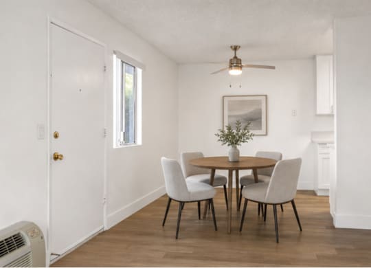 A dining room with a table set for four.