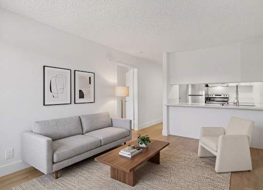 A living room with a grey couch, a coffee table, and a chair.