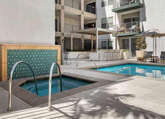 A pool with a diving board in front of a building.