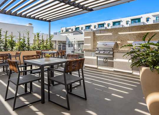 A patio with a table and chairs under a striped awning.
