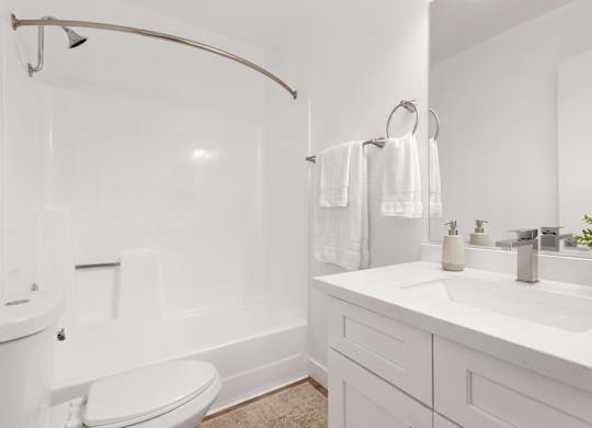 A white bathroom with a toilet, sink, and bathtub.