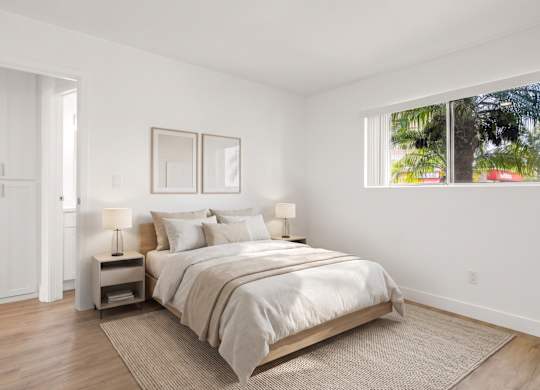A bedroom with a large bed, two nightstands, and a window.