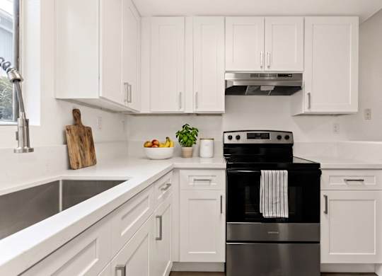 A modern kitchen with a black stove top oven.