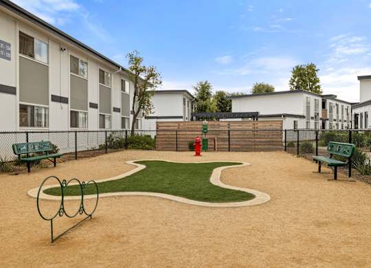 A playground area with a slide, swings, and a sandbox.
