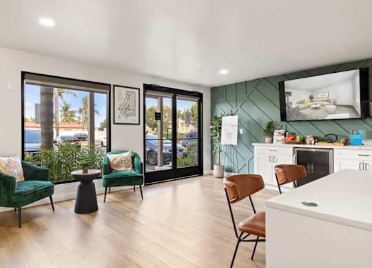A modern living room with a green chair and a white kitchen in the background.