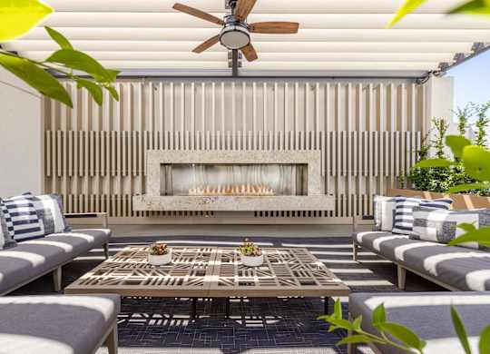 A patio with a fireplace and a table with chairs.