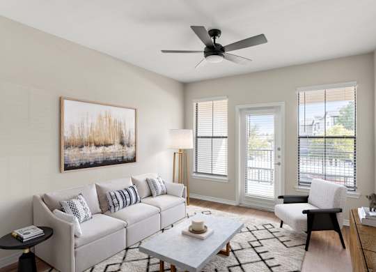 A living room with a grey couch, a coffee table, a chair, and a painting on the wall.
