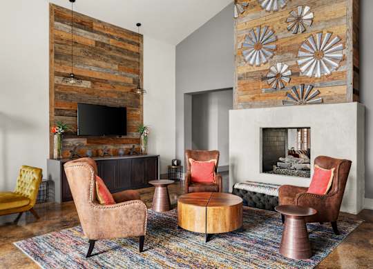 A living room with a fireplace and a wooden wall.