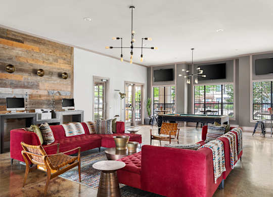 A living room with a red couch and a wooden wall.