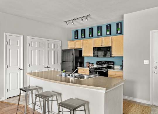 A kitchen with a white counter and bar stools.