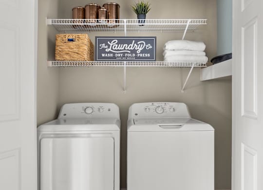 A laundry sign hangs above a shelf with towels and a basket.