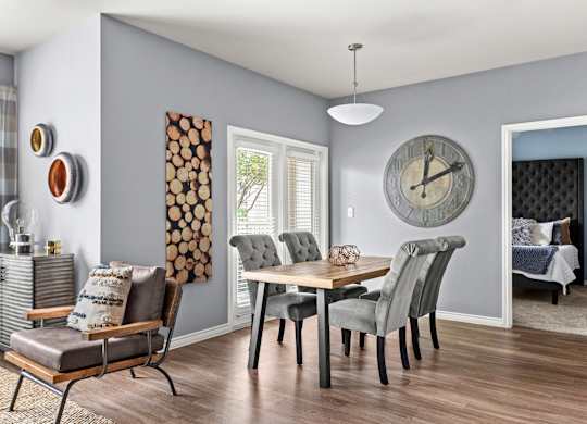 A grey and white dining room with a wooden table and chairs.