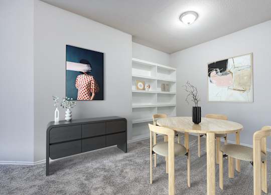 A room with a round table and chairs, a dresser, and two paintings on the wall.