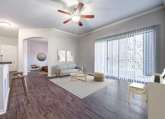 A living room with a couch, chair, and a fan.