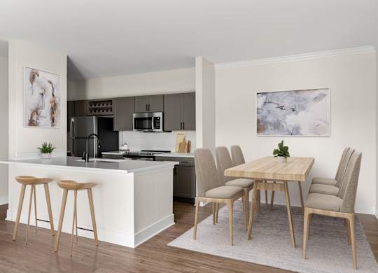 A kitchen with a bar and a dining table with chairs.