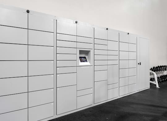 A wall of white lockers with a small door on the side.