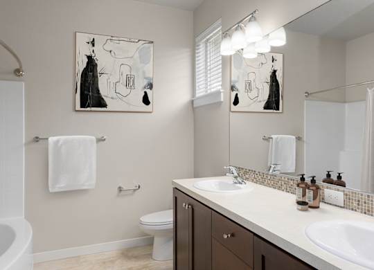 A bathroom with a toilet, sink, and mirror.