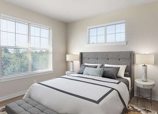 A bedroom with a large bed and a window with blinds.
