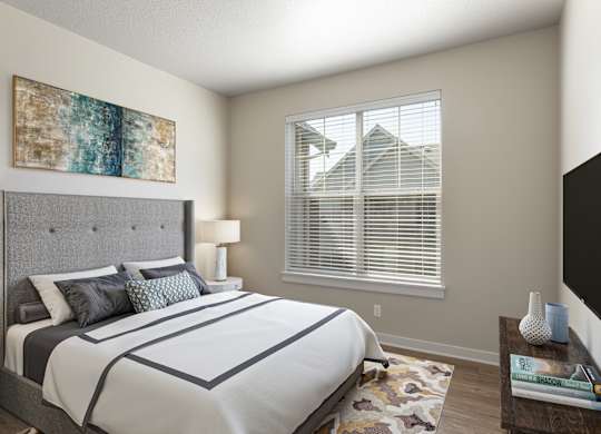 A bedroom with a large bed and a painting on the wall.