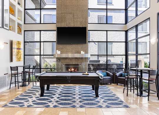 A living room with a pool table and a fireplace.