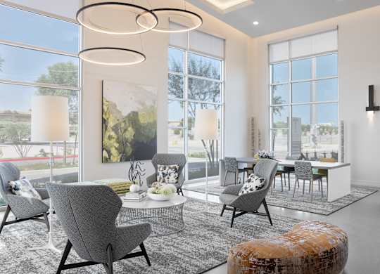 A modern living room with grey chairs and a large window.