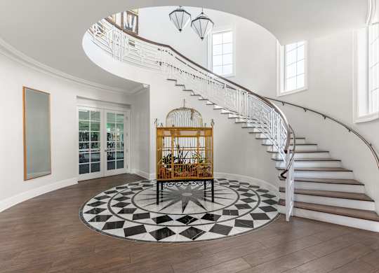 A spiral staircase in a home with a black and white floor.