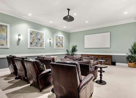 A room with brown leather chairs and a whiteboard on the wall.