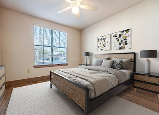 A bedroom with a large bed, a ceiling fan, and a window with blinds.