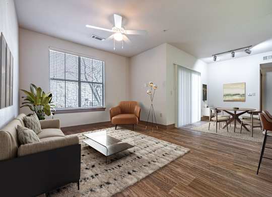 A living room with a brown sofa, a coffee table, and a chair.