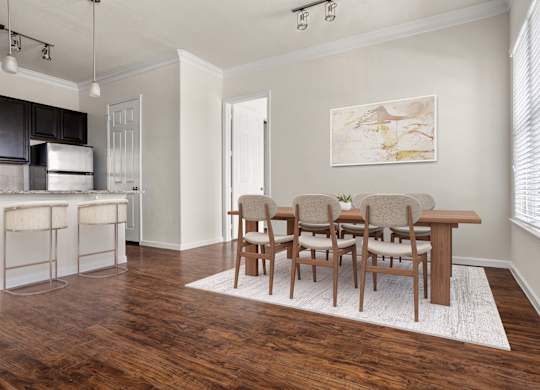 A kitchen with a bar and chairs.