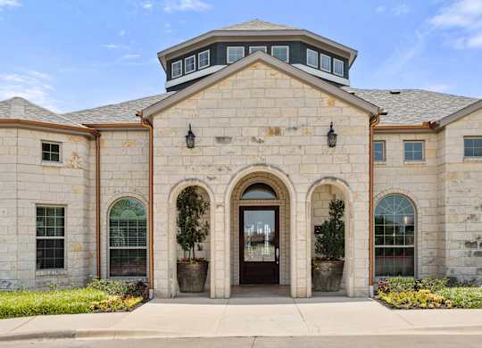 A stone building with a large arched entrance and a round window above it.