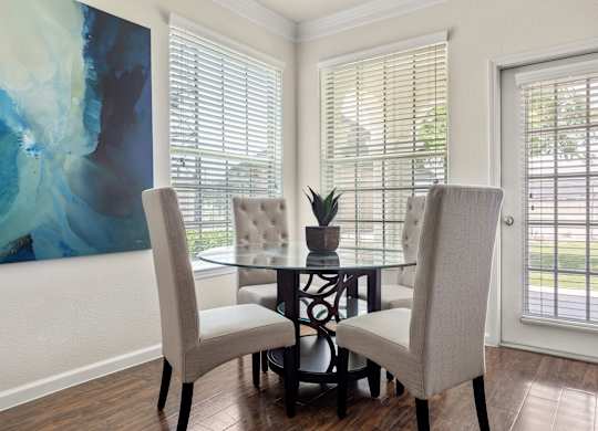 A dining room with a glass table and chairs.