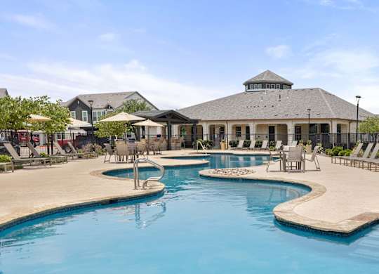 A large swimming pool with a building in the background.