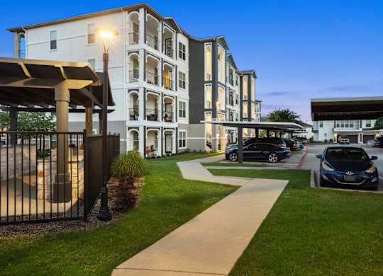 A modern apartment complex with a walkway in front.