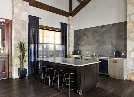 A kitchen with a large island and stools.