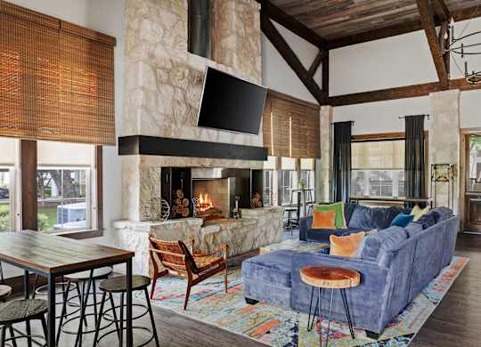 A living room with a stone fireplace and a blue couch.