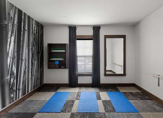 A room with a checkered carpet and a window with curtains.