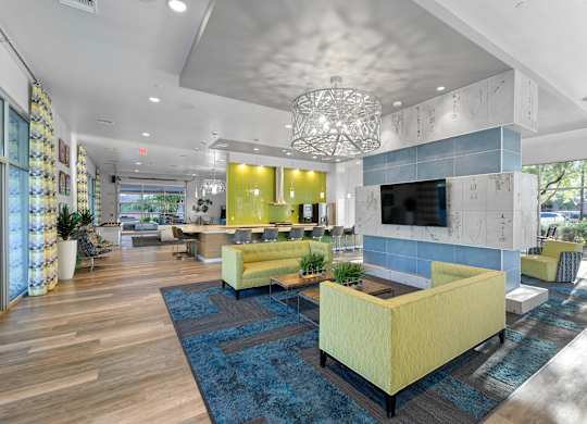 A modern living room with a yellow sofa and a blue rug.