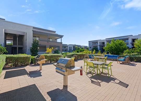 A sunny day at a residential complex with a wooden deck and outdoor furniture.