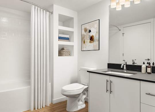 A white bathroom with a toilet, sink, and shower curtain.